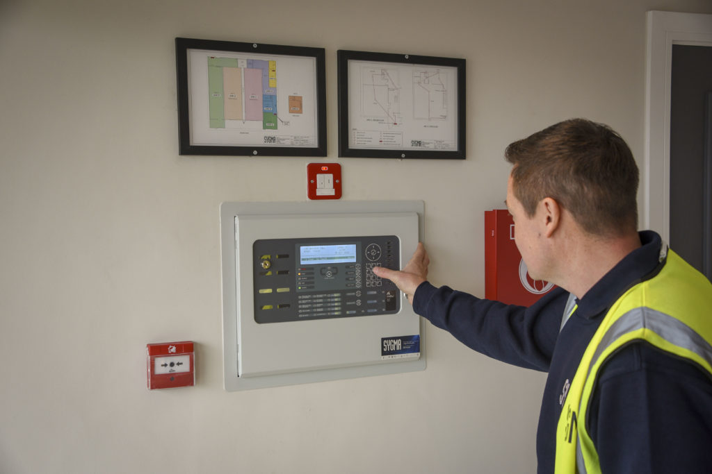 Sygma engineer testing a fire alarm control panel